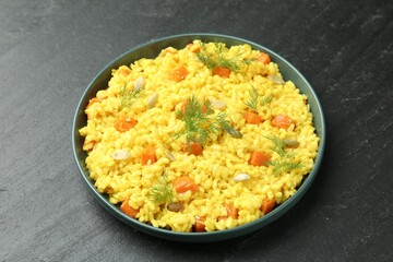 Delicious pumpkin risotto in bowl on black table, closeup