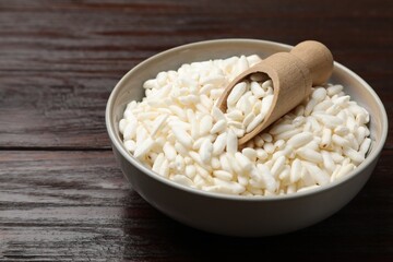 Puffed rice in bowl and scoop on wooden table, closeup