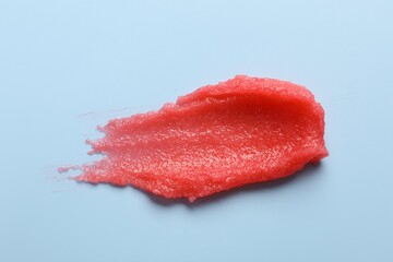 Smear of body scrub on light blue background, top view