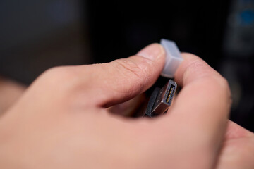 A Close Up View of Hands Gripping a USB Connector With Great Attention to Detail and Focus