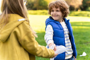 Children working together in park to protect environment collecting trash
