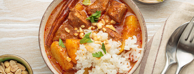 Aromatic massaman curry, a staple of thai cuisine, with tender beef, potatoes, and fluffy rice, garnished with peanuts and fresh herbs, a vibrant and flavorful dish of Thailand