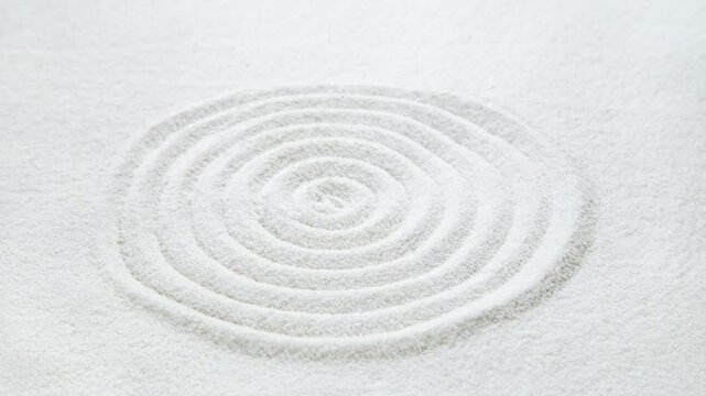Zen circle pattern in white sand through the water