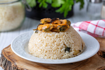 Mussel rice pilaf. Rice with mussels on small white plate on ceramic. (Turkish name; midyeli pilav)