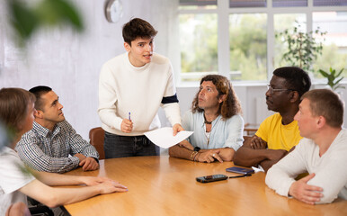 Group of men discussing something at a desk in the audience