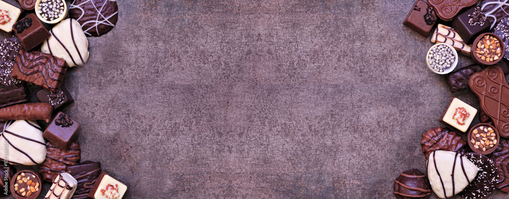 Poster chocolate double border with an assortment of fine, luxurious sweets. top view on a dark stone banne