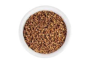 Raw buckwheat in ceramic bowl isolated on white background. Top view. Flat lay