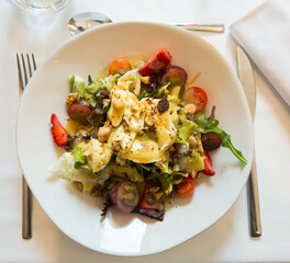 Spanish cuisine, salad with arugula, tomatoes, strawberries, grapes, nuts and goat cheese