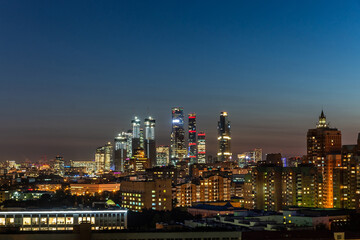 Naklejka premium A twilight view of skyscrapers illuminating the skyline of a bustling city as night falls over the urban landscape