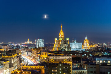 Obraz premium Illuminated Moscow skyline at night showcasing historic buildings with a crescent moon above