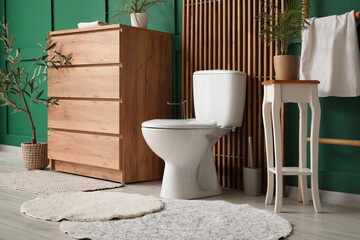 Interior of restroom with toilet bowl, commode and table