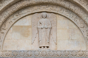 Pavia - The detail of St. Michael archangel from romanesque portal of church Basilica di San Michaele Maggiore