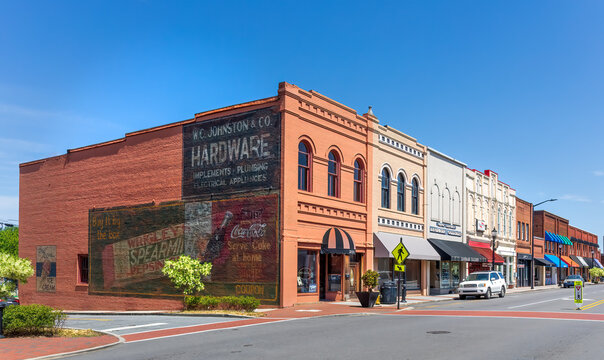 MOORESVILLE, NC, USA-17 APRIL 2022:View of a block of historic downtown buildings, with old painted advertising on end wall.  View from North Main and West Moore Ave. 
