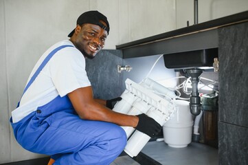 African american plumber change the water filter.