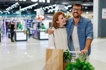 Happy couple shopping for groceries at the supermarket