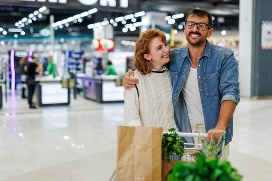 Happy couple shopping for groceries at the supermarket
