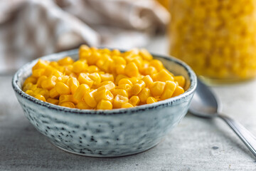 Canned sweet corn in bowl on kitchen table.