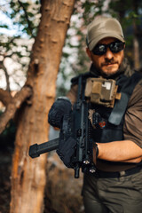 Fototapeta premium Soldier holding a submachine gun in the forest during a military operation