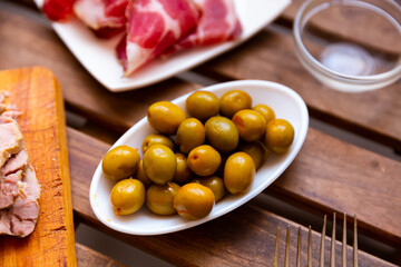 Typical Spanish tapas - appetizing pickled green olives with a stone