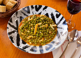 Hearty and healthy lunch is young green peas stewed with pieces of squid. Low-calorie protein diet, healthy eating