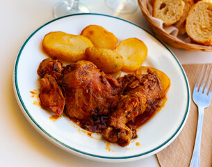 Appetizing chicken legs with potatoes and sauce