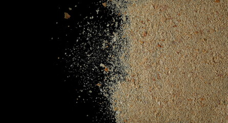 Nutritional yeast pile (deactivated yeast) isolated on black, top view