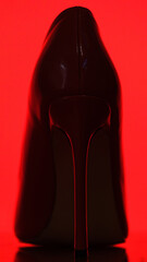 red stiletto heel on red background