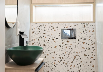 Modern bathroom in a modern style. Ceramic green bathroom sink on a cabinet with tao and pattern...