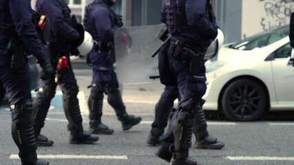 A large march in a European city, escorted by police officers.