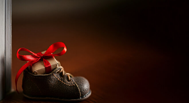 Wrapped gift box in a child's show present placed in shoes saint nicholas day christmas present for children with copy space