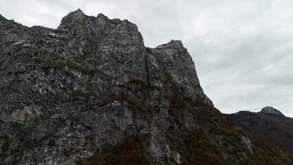 Autumn view of golden forest and green fields in the Grebaje Valley in the Prokletije National Park in northern Montenegro, on the border with Albania. A breathtaking bird's-eye view of the landscape.