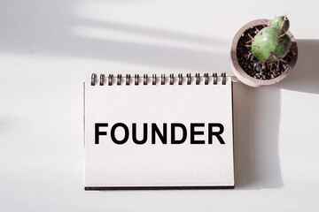 White Notebook With The Word Founder Written On It