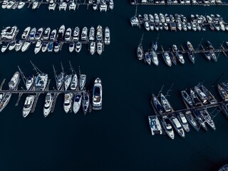 Aerial view of numerous boats and yachts docked in a busy marina during the daytime