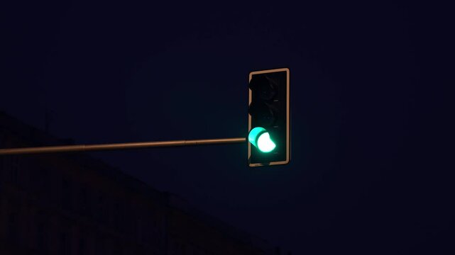 A traffic light changes from red to green at night.