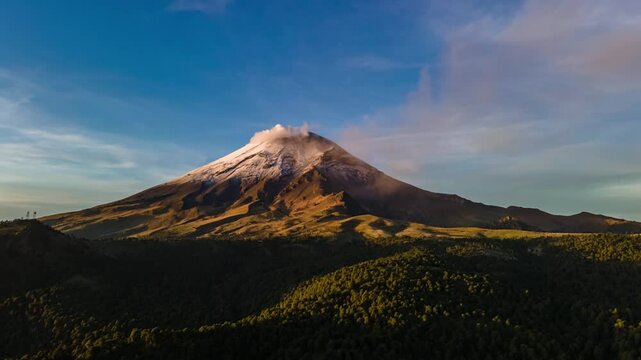 Lateral aerial hyperlapse of the active Popocatepetl volcano captured at sunrise during the golden hour. A stunning view showcasing the majesty of the volcanic landscape and the soft morning light.