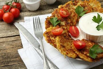 Delicious potato pancakes served on wooden table, closeup