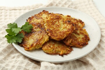 Delicious potato pancakes and parsley on table, closeup