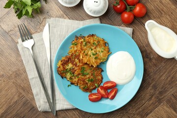 Delicious potato pancakes served on wooden table, flat lay