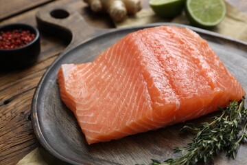 Salmon fillet and thyme on wooden table, closeup