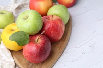 Different whole ripe apples on white table, closeup