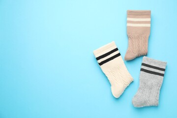 Different comfortable socks on light blue background, flat lay. Space for text