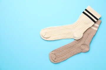 Different comfortable socks on light blue background, flat lay. Space for text