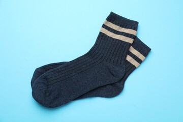 Pair of soft comfortable socks on light blue background, top view