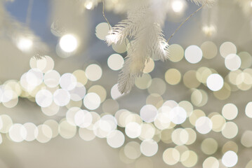 Merry christmas and new year holidays background. Blurred bokeh background with light bulbs and Christmas tree branches.