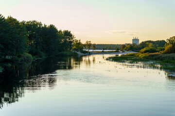 Peaceful river scene with trees and reflections at sunset