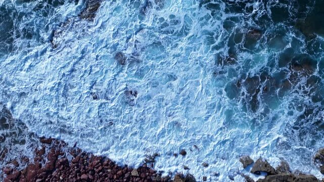 ripresa cinematica aerea del faro mangiabarche in Sardegna in italia, durante una durante una forte mareggiata con onde che si infrangono sugli scogli