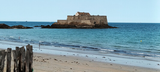 Ancient Fortress on Rocky Island Overlooking Serene Beach and Turquoise Sea