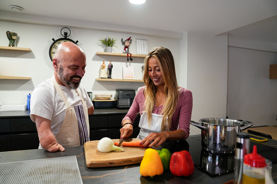 Disability man cooking with friend, enjoying kitchen moments