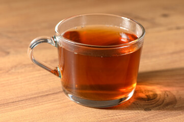 Warm cup of herbal tea resting on a rustic wooden table in a cozy afternoon setting, inviting comfort and relaxation