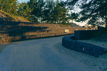 Winding path with stone walls in a wooded park at sunset